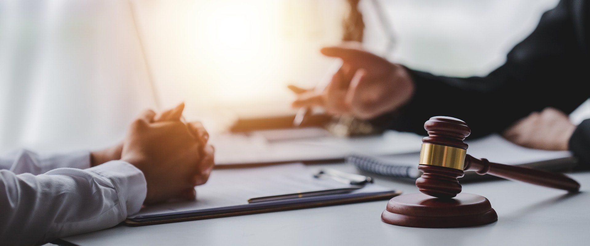 concept of justice and law A male judge in the courtroom on a wooden table and a male counselor or lawyer working in the office. Law, advice and justice concepts.