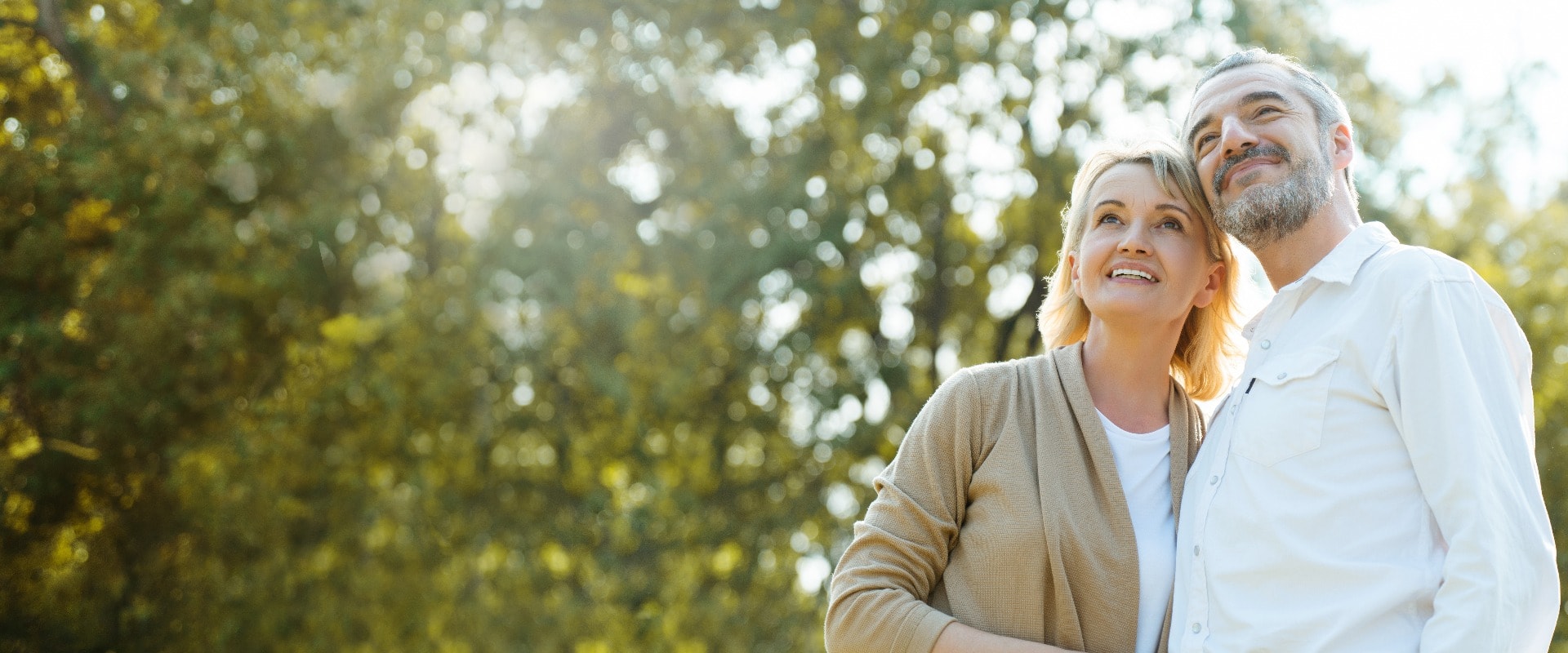 Senior Caucasian couple hugging in park. Family with a happy smile feels relaxed with nature in the morning. Or in the evening. Enter elderly society And retire from work. Concept health insurance
